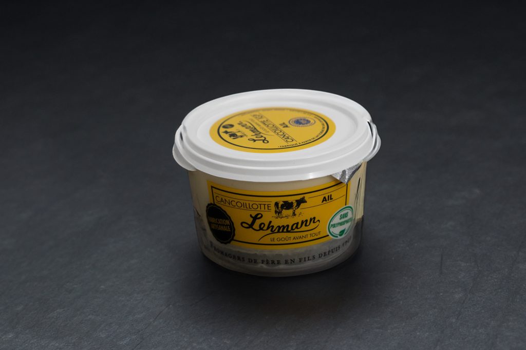 Pot de Cancoillotte à l'ail à l'étiquette jaune, sur ardoise