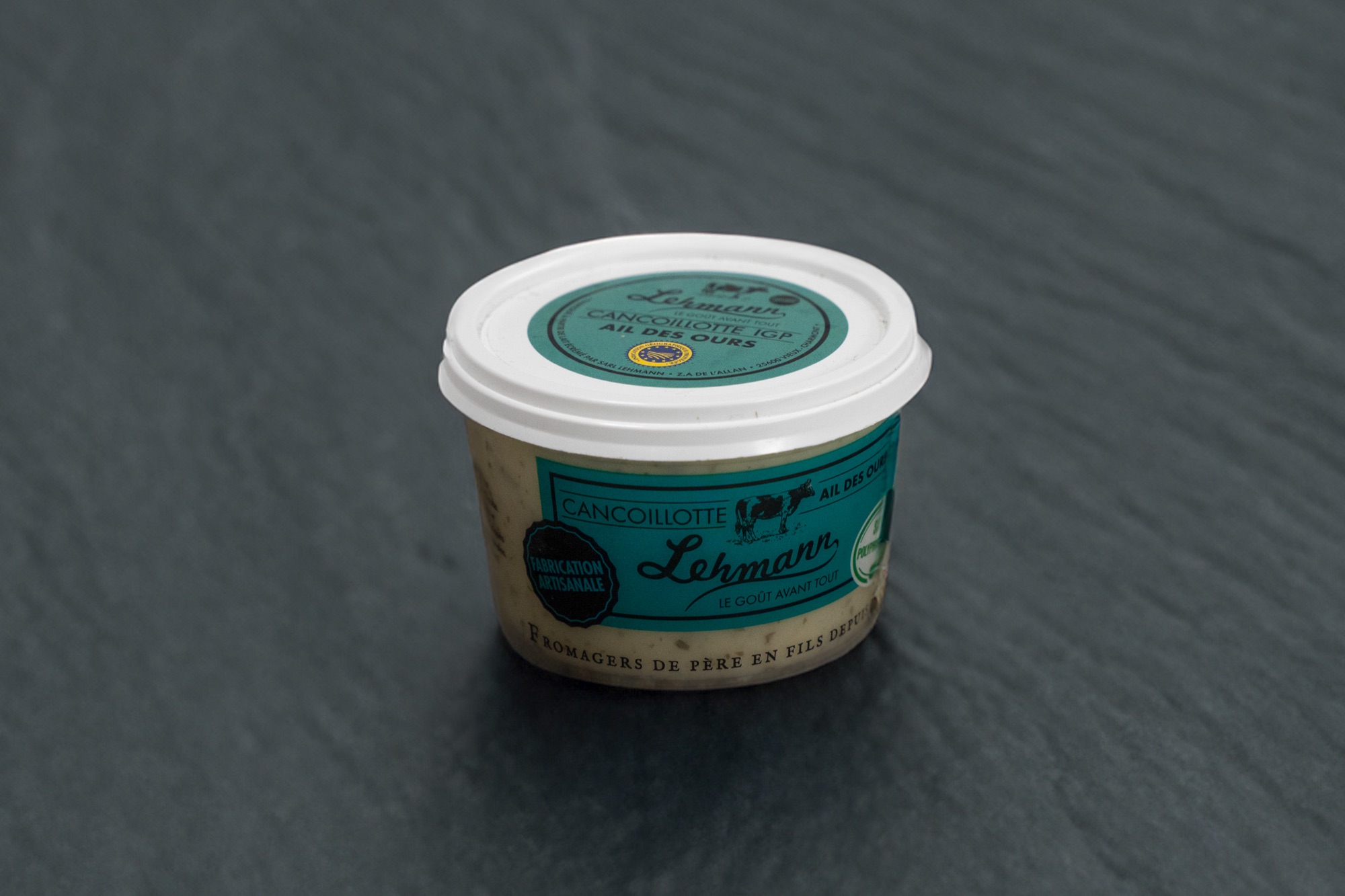 Pot de Cancoillotte à l'ail des ours à l'étiquette verte, sur ardoise
