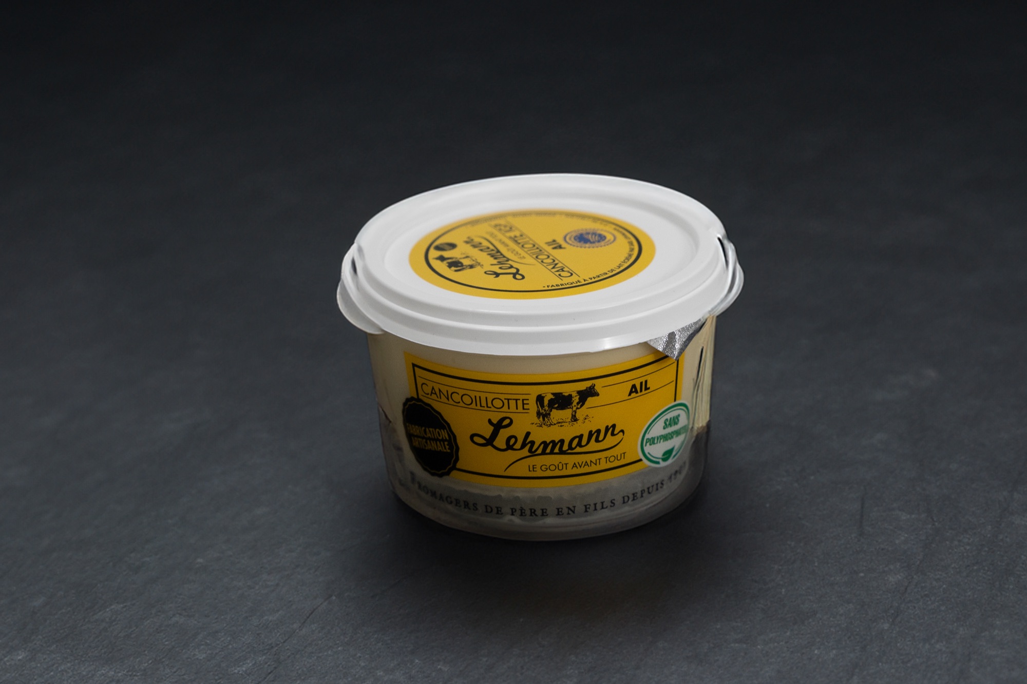 Pot de Cancoillotte à l'ail à l'étiquette jaune, sur ardoise