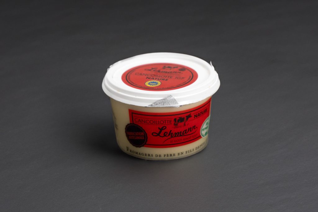 Pot de Cancoillotte nature à l'étiquette rouge, sur ardoise