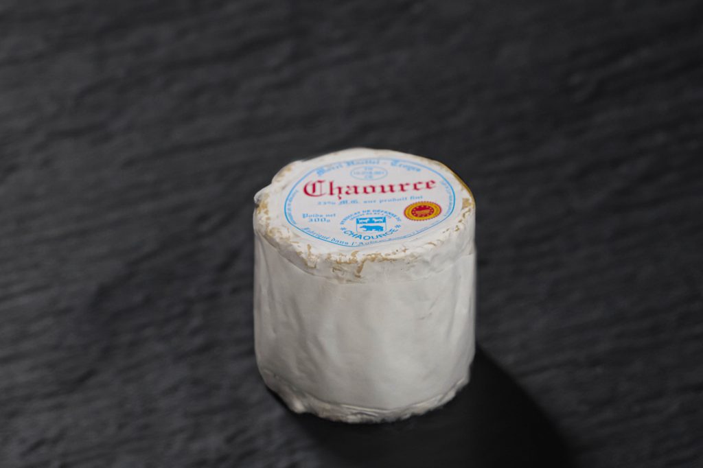 Chaource coupé, pâte crémeuse sous une croûte fleurie blanche, sur ardoise