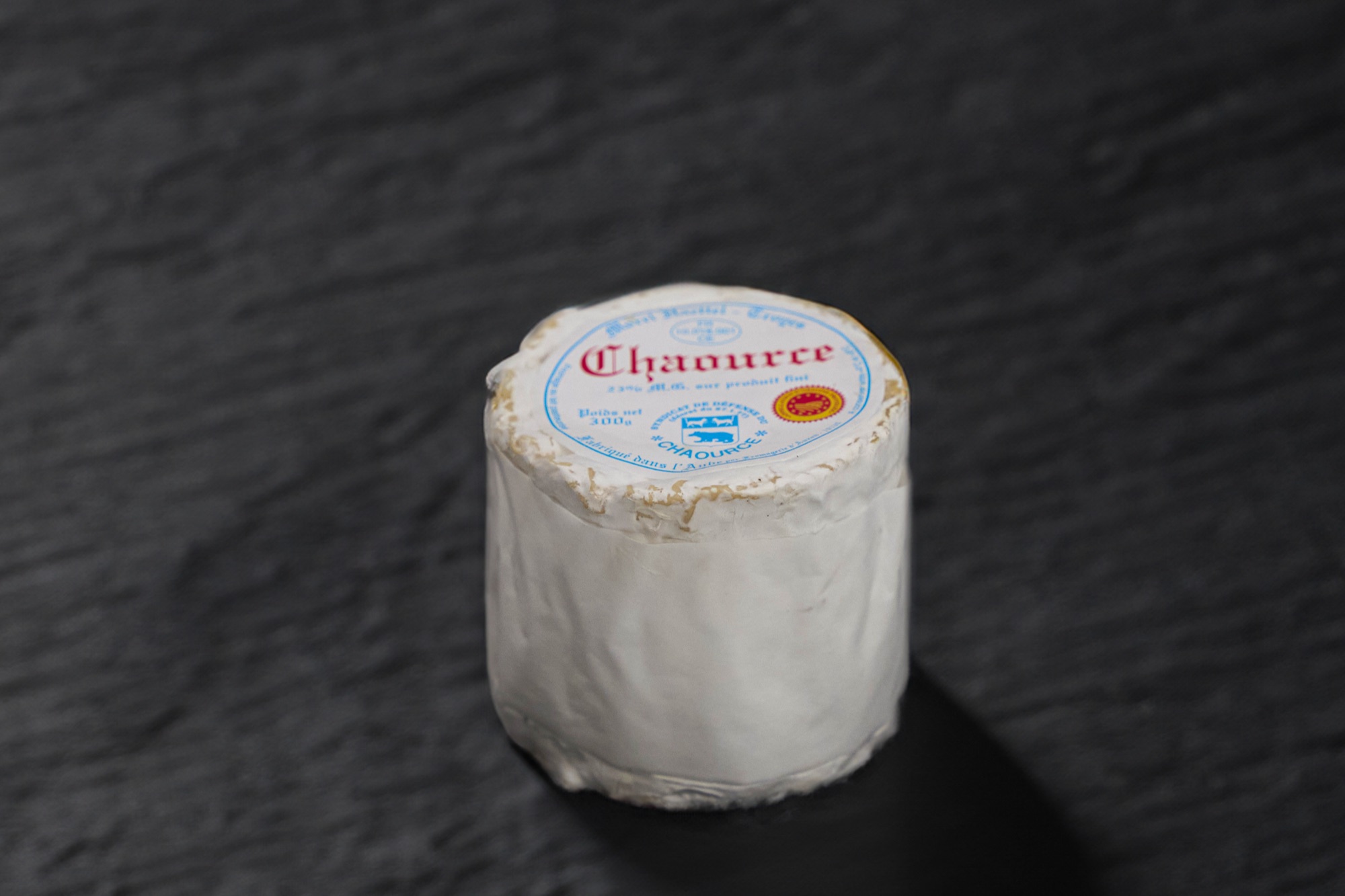 Chaource coupé, pâte crémeuse sous une croûte fleurie blanche, sur ardoise