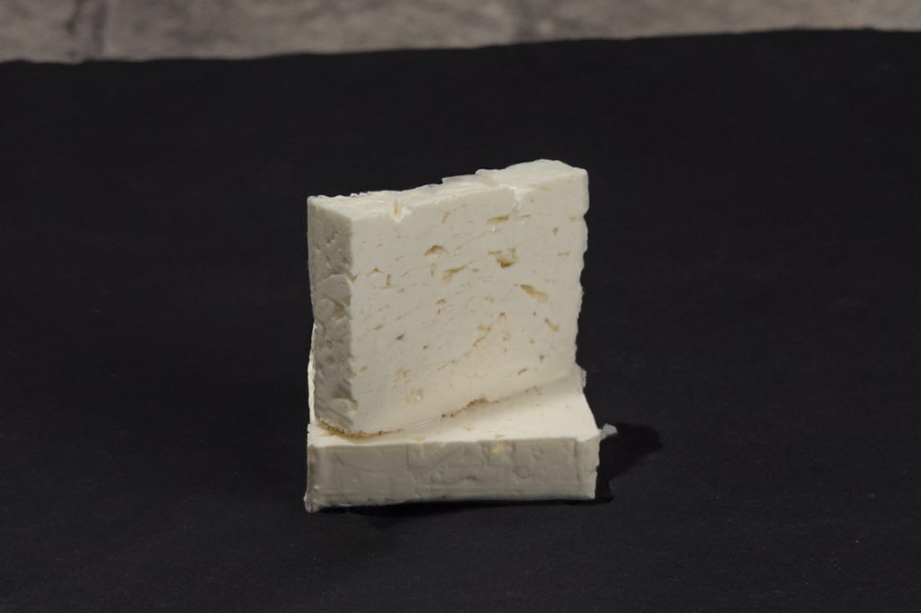 Blocs de feta blanche superposés sur fond sombre