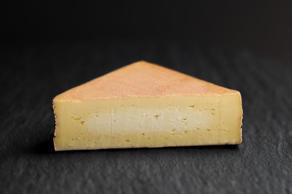 Maroilles à croûte lavée orangée coupé, sur ardoise