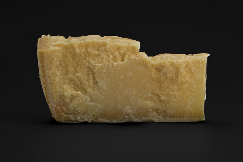 Morceau de parmesan 24 mois à pâte granuleuse sur ardoise